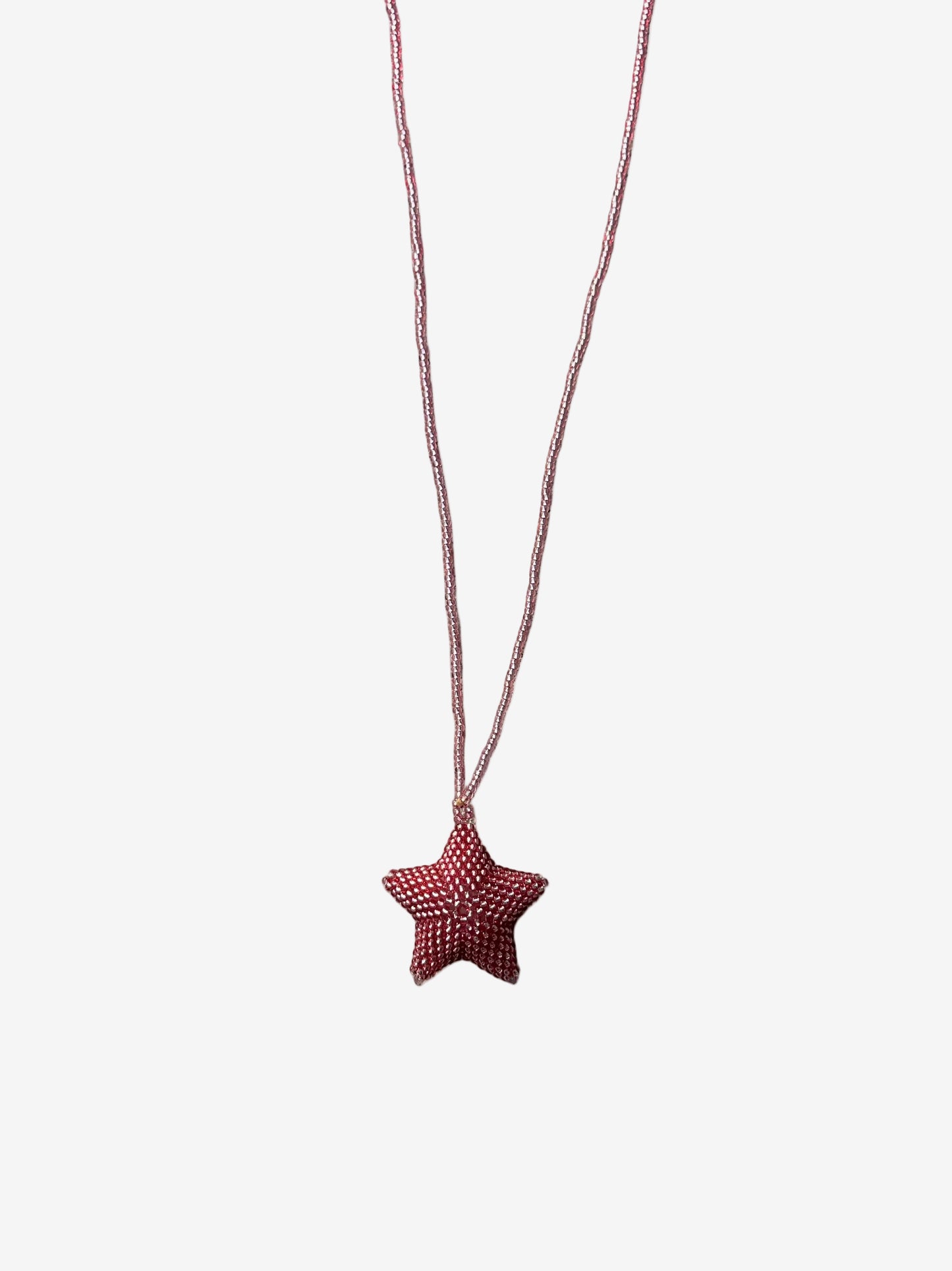 Star-shaped pink pendant on a string 